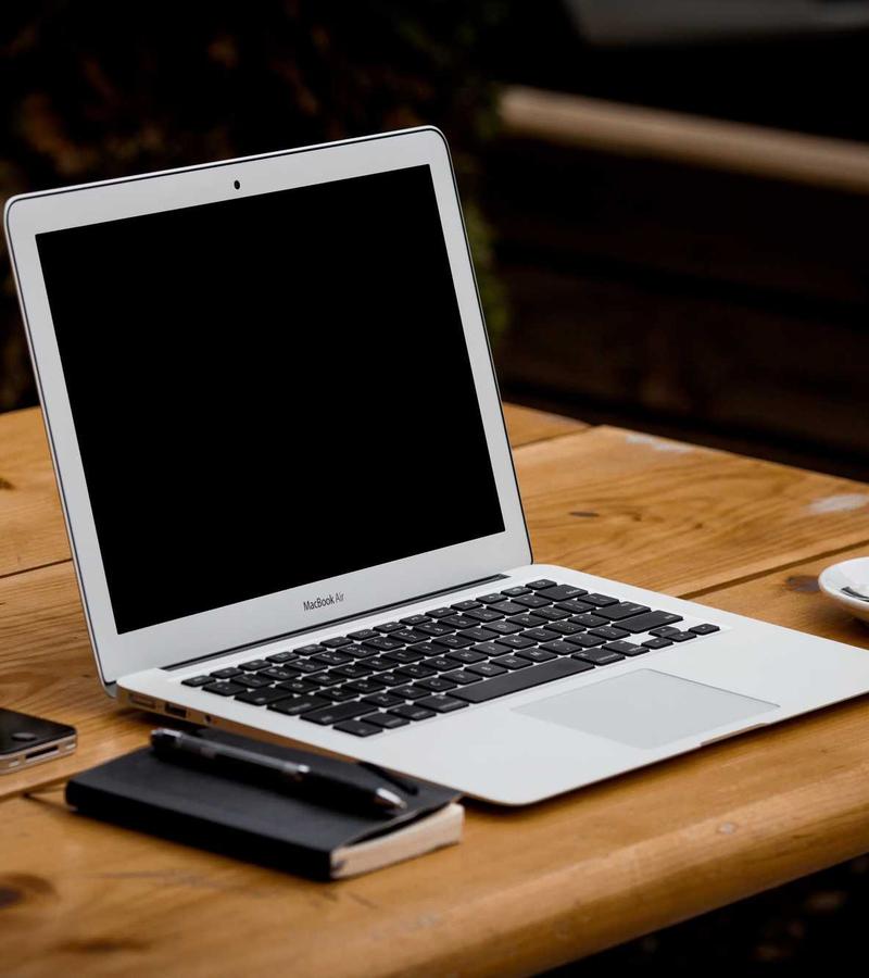 Laptop, notebook, and coffee on a desk during a project planning session